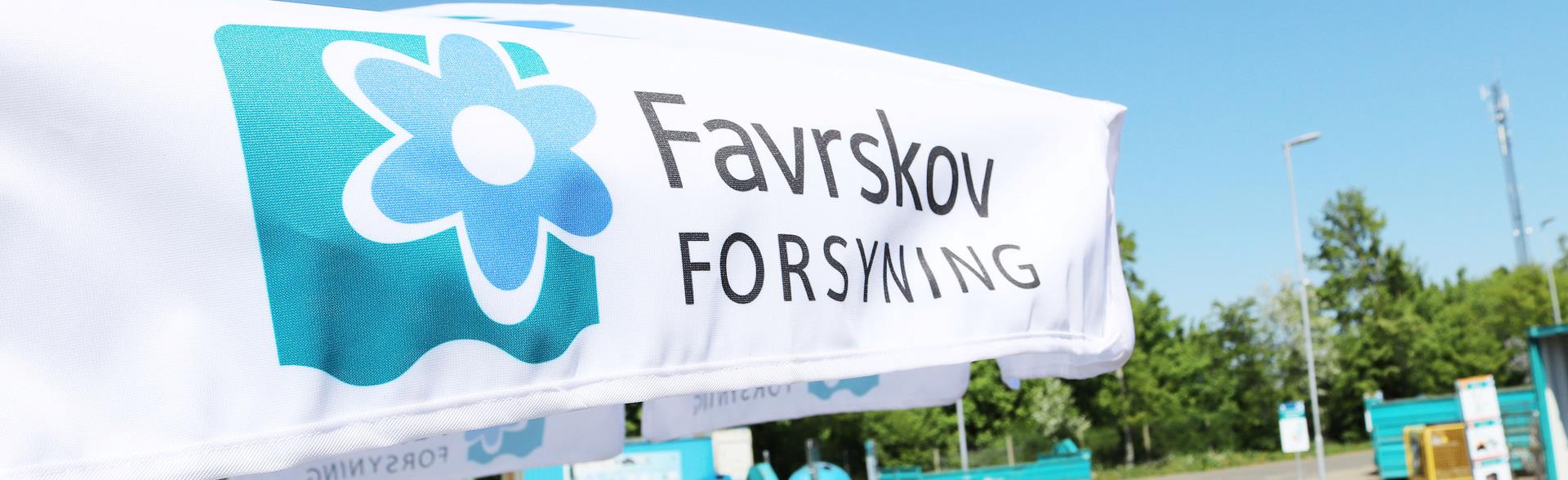 Pasasol på genbrugsplads med Favrskov Forsynings logo