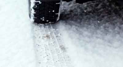 Bil laver hjulspor på vej med sne