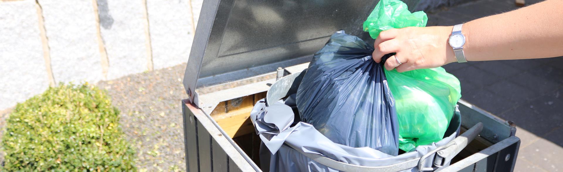 To affaldsposer lægges ned i sæk til restaffald