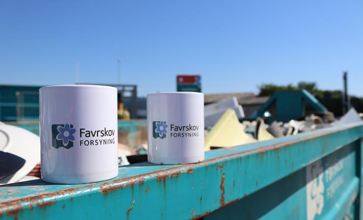To kopper med favrskov forsynings logo står på kant af container