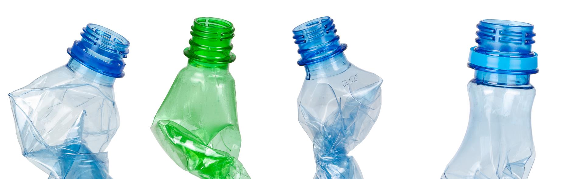 Fire plastflasker der er krøllet sammen
