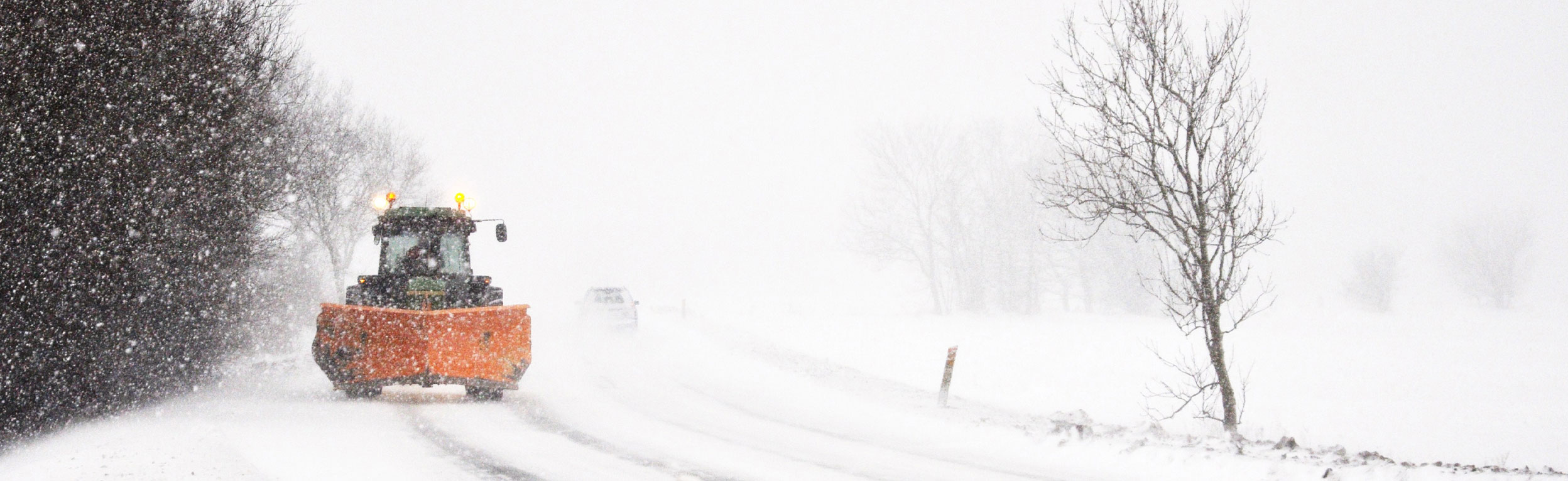 Sneplov kører på snebelagt landevej