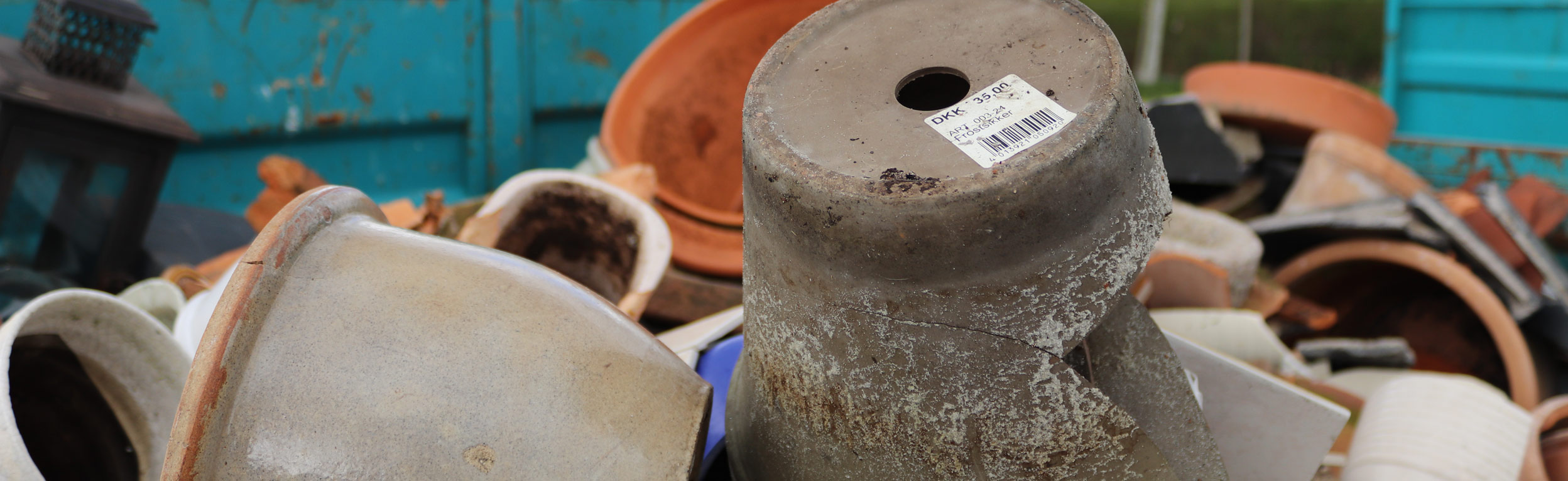 Krukker og andet keramik ligger i container på genbrugsplads