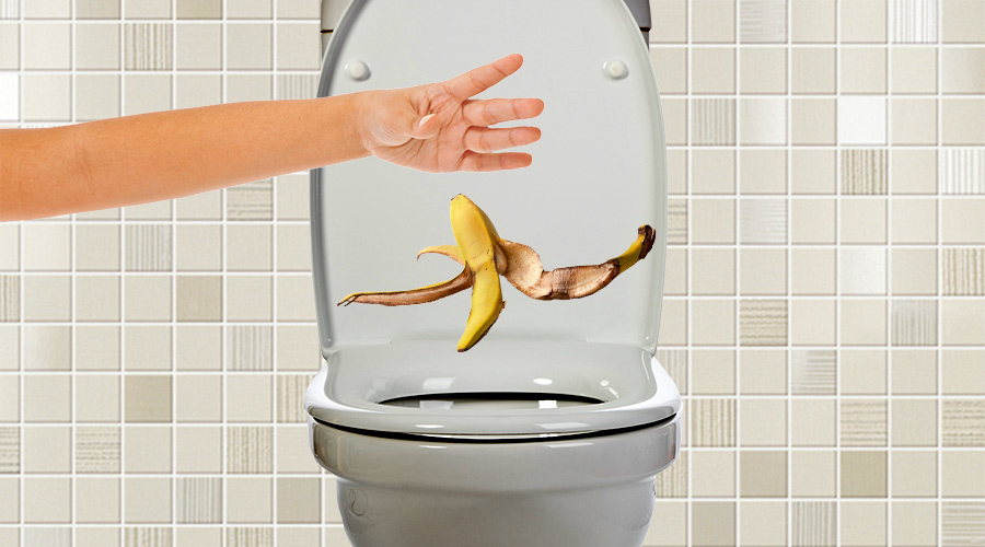 person holder en bananskrald henover toilet