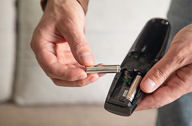 Person tager batterier ud af fjernbetjening