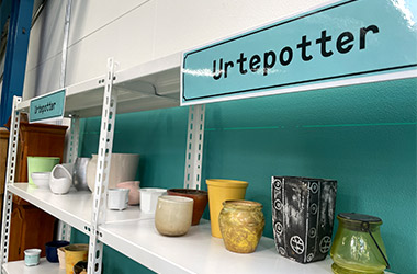 Urtepotter og forskellige porcelænting står på hylder