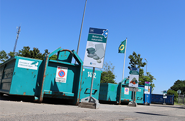 Grønne containere og skilte på genbrugsplads